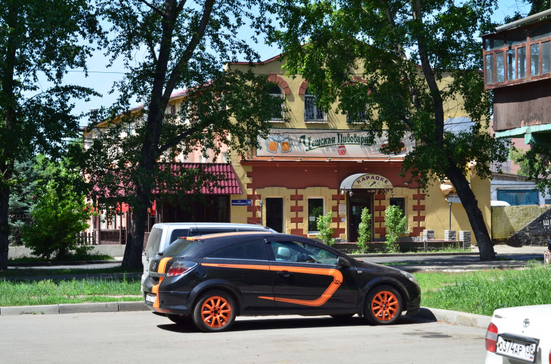 Разукрашенная машина на фоне пивнушки